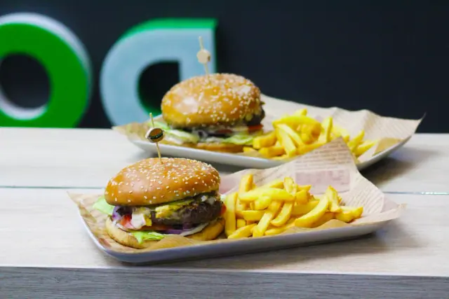 Dva burgera sa pomfritom ispred DOT. zida